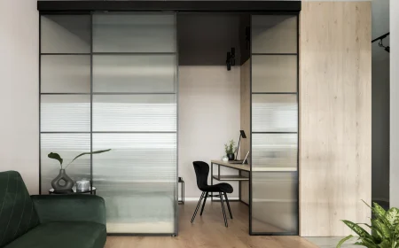 glasschiebetür trennt wohnzimmer und schlafbereich mit schreibtisch