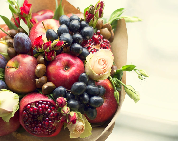 Herbststrauß mit Obst in roten und blauen Farben mit einem Hauch Rosa und Grün
