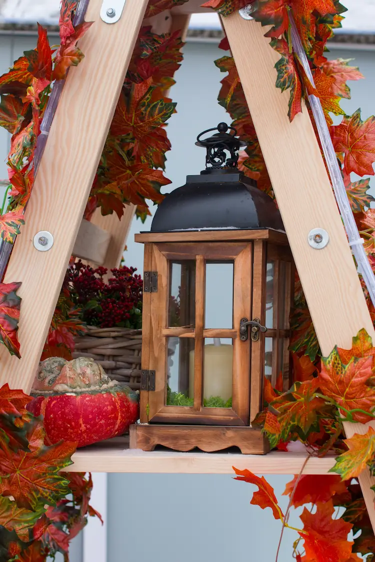 Laterne als Akzent auf Weinkisten arrangieren als Gartendeko im Herbst 