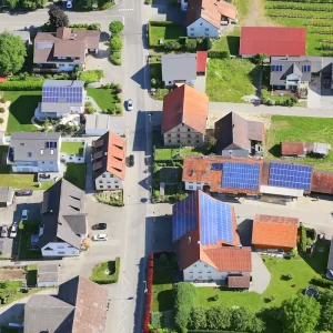 luftaufnahme eines dorfes mit zahlreichen photovoltaikanlagen – solarenergie im alltag