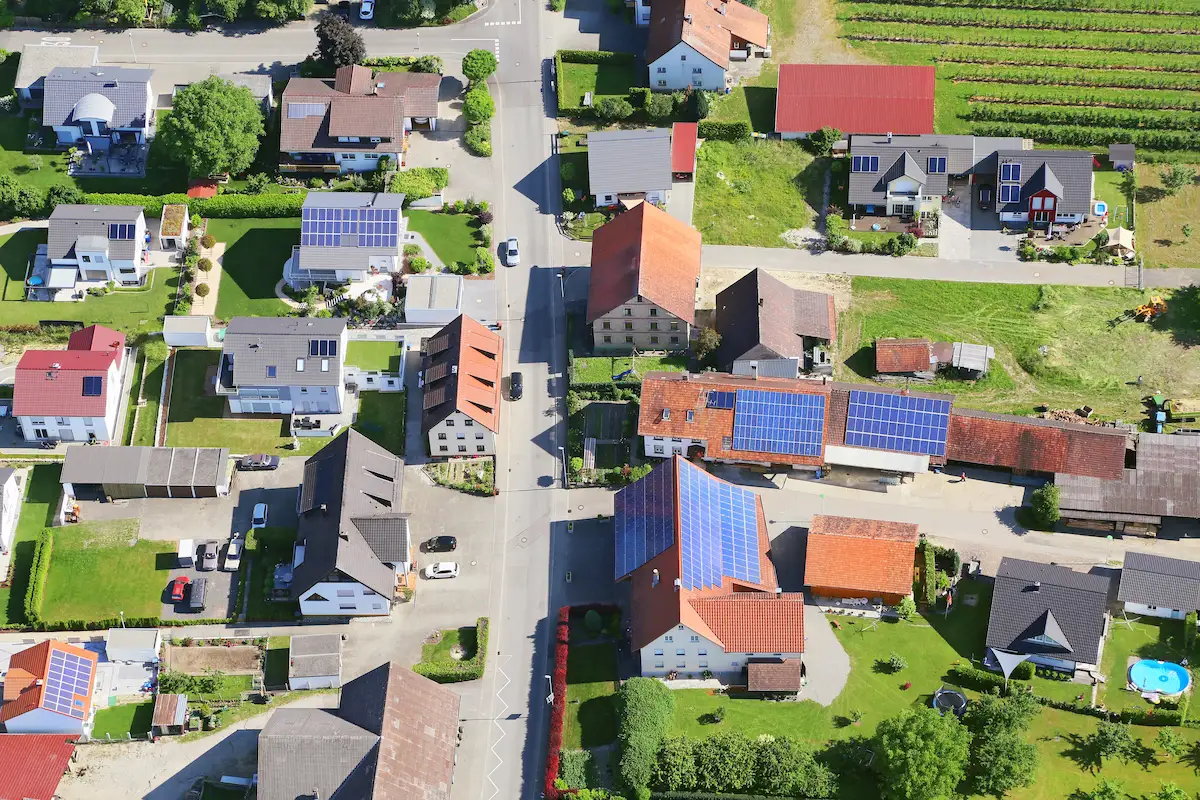luftaufnahme eines dorfes mit zahlreichen photovoltaikanlagen – solarenergie im alltag