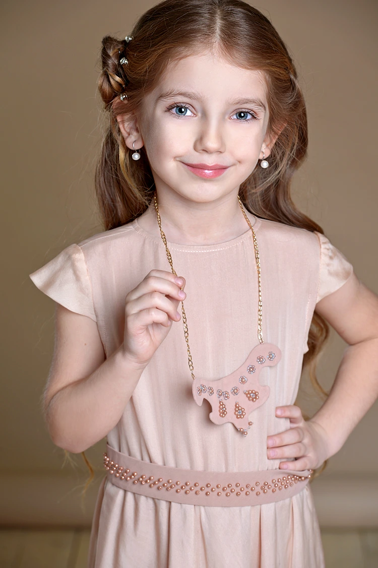 mädchenfrisur zur kommunion mit wasserfallzopf und haarblume