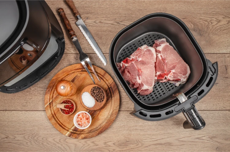rohe schweinekoteletts mit gewürzen, zubereitet zum garen im airfryer