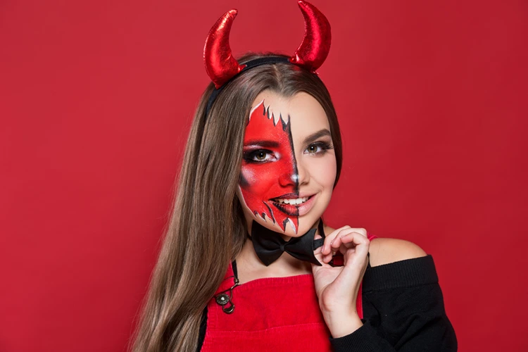 Teufel mit halbem Gesicht aus roter Schminke gestalten