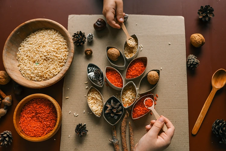 Zum Fördern der Feinmotorik mit einem Löffel arbeiten