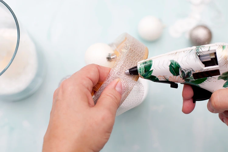 das silberne dekoband wird mit heißkleber sauber am holzdeckel befestigt