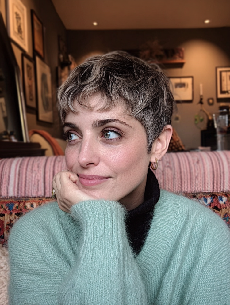 frau mit grünem pullover und whisper pixie cut mit blonden strähnchen