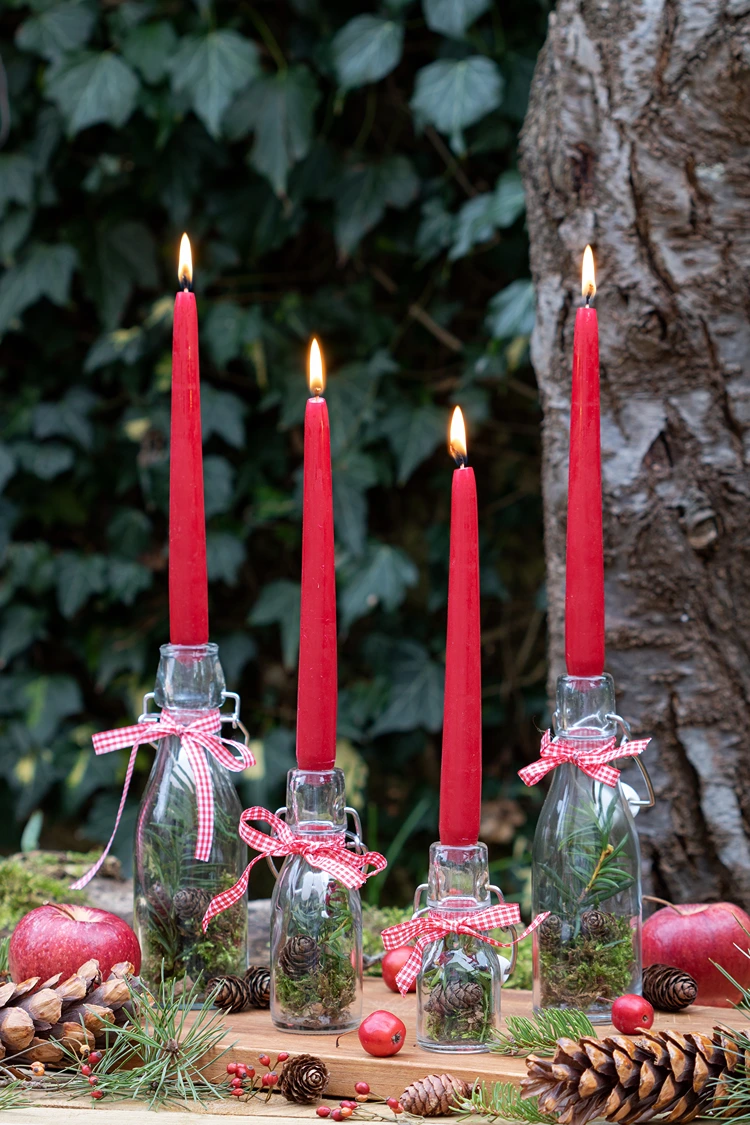 Glasflaschen mit Naturmaterialien füllen und Stabkerzen aufstecken
