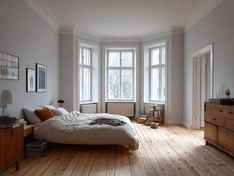 Hellgrau mit warmem Unterton in einem Schlafzimmer mit Holzmöbeln