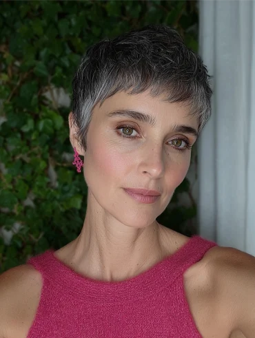 reife frau mit whisper pixie schnitt in grauer farbe und rosa oberteil