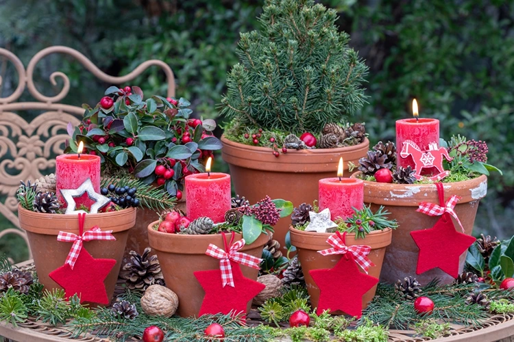 Tontöpfe mit Stumpenkerzen, Beeren und Weihnachtsdeko