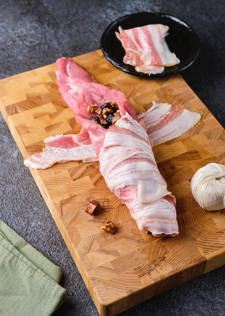 Füllung im Fleisch verteilen und mit Bacon einwickeln