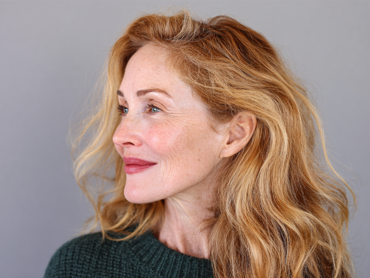 50+ frau mit welligem kupferfarbenem haar und seitenscheitel