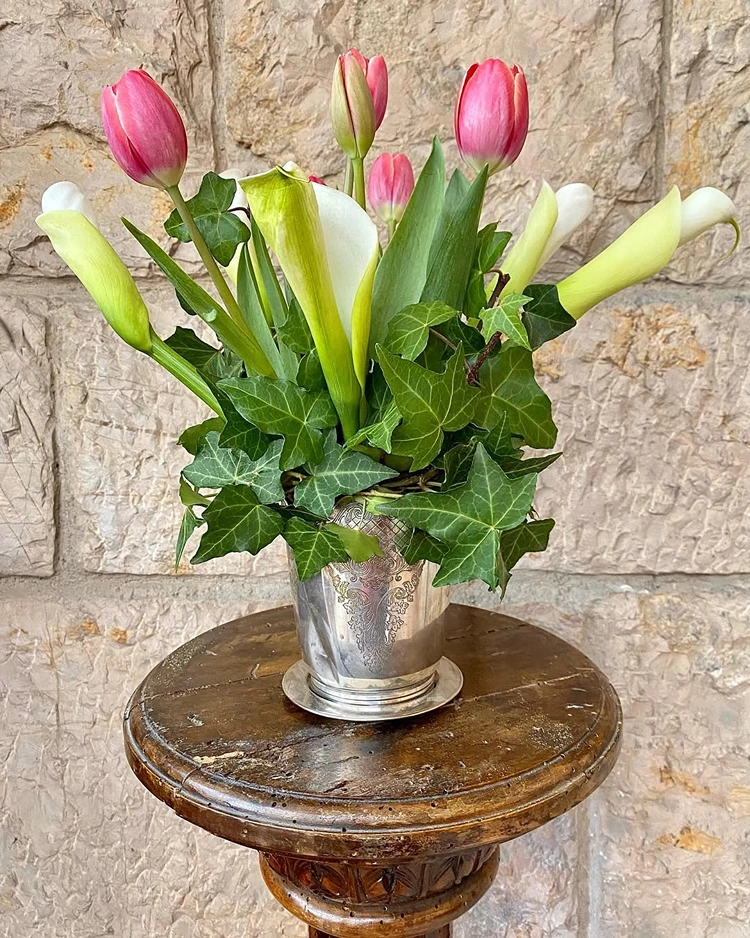 Frühlingsstrauß mit rosa Tulpen, Calla und Efeuranken in einer Metallvase