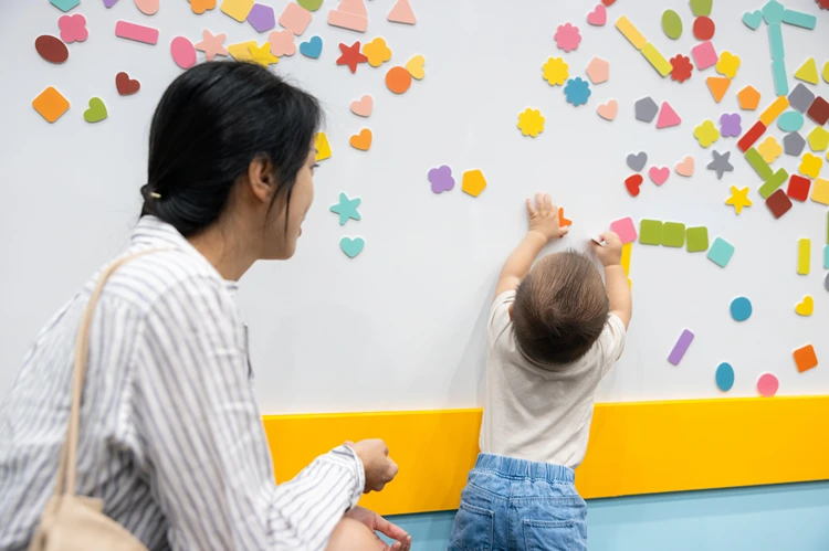 kleinkind spielt mit bunten magneten