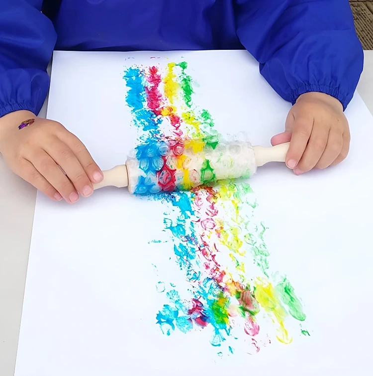 Folie um Nudelholz wickeln und mit Farben auf Papier rollen